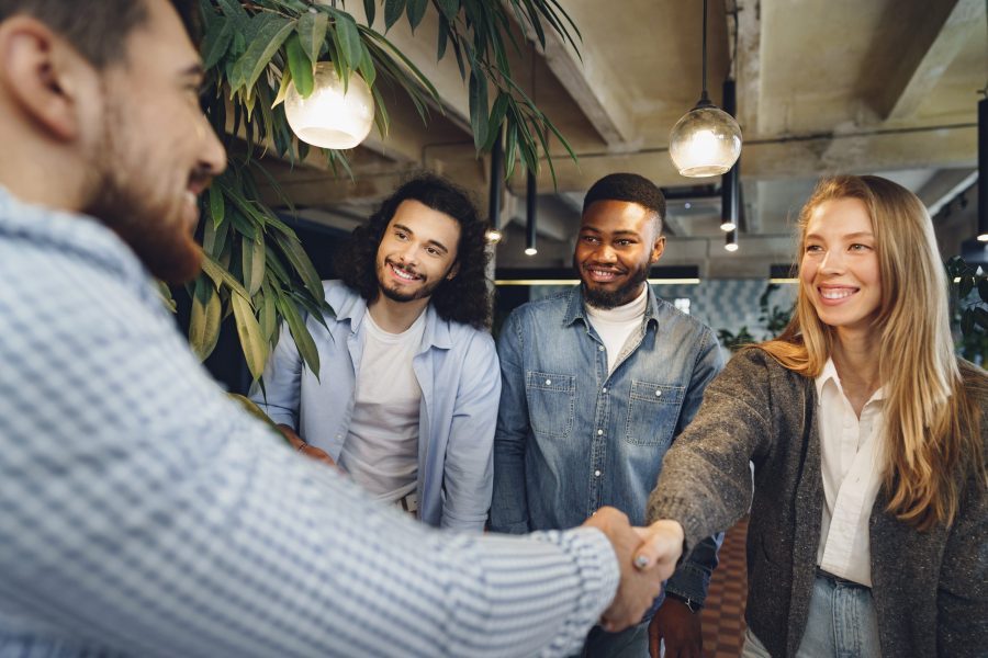 Female office executive shaking hand of new male team member employee, close up